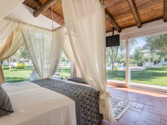 Camera da letto con bellissima vista sul giardino. Fotografia di interni realizzata nel Ristorante Locanda Da Renzo, provincia di Oristano