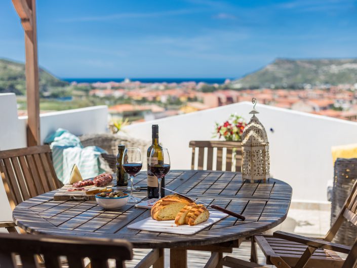 Aperitivo su una terrazza panoramica a Bosa. Fotografia per il settore immobiliare in Sardegna