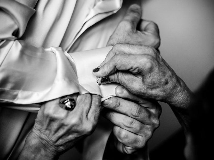 Dettagli di Matrimonio. La madre aiuta il figlio a vestirsi.